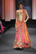 Gleaming fully embroidered designer lehenga with golden choli and contrast orange dupatta